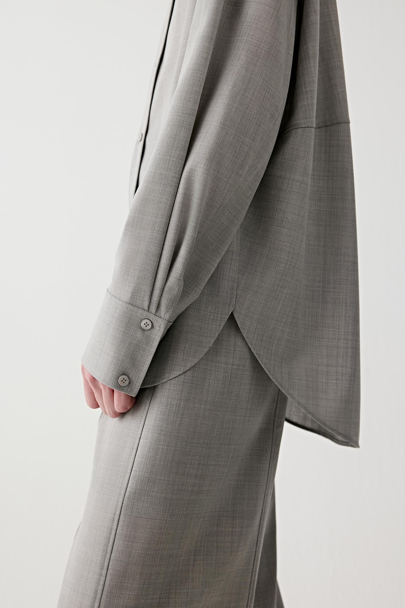 Detail of the wool texture and sleeve finish in light grey melange.
