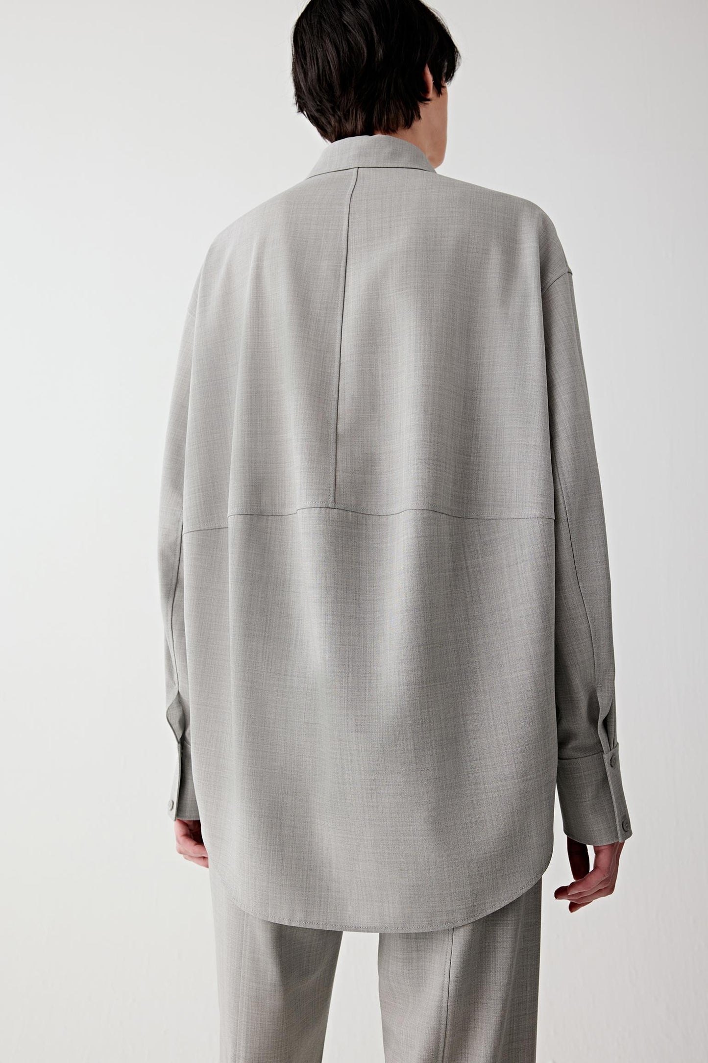 Back view of the light grey twist wool shirt highlighting the straight cut and clean shoulder line.
