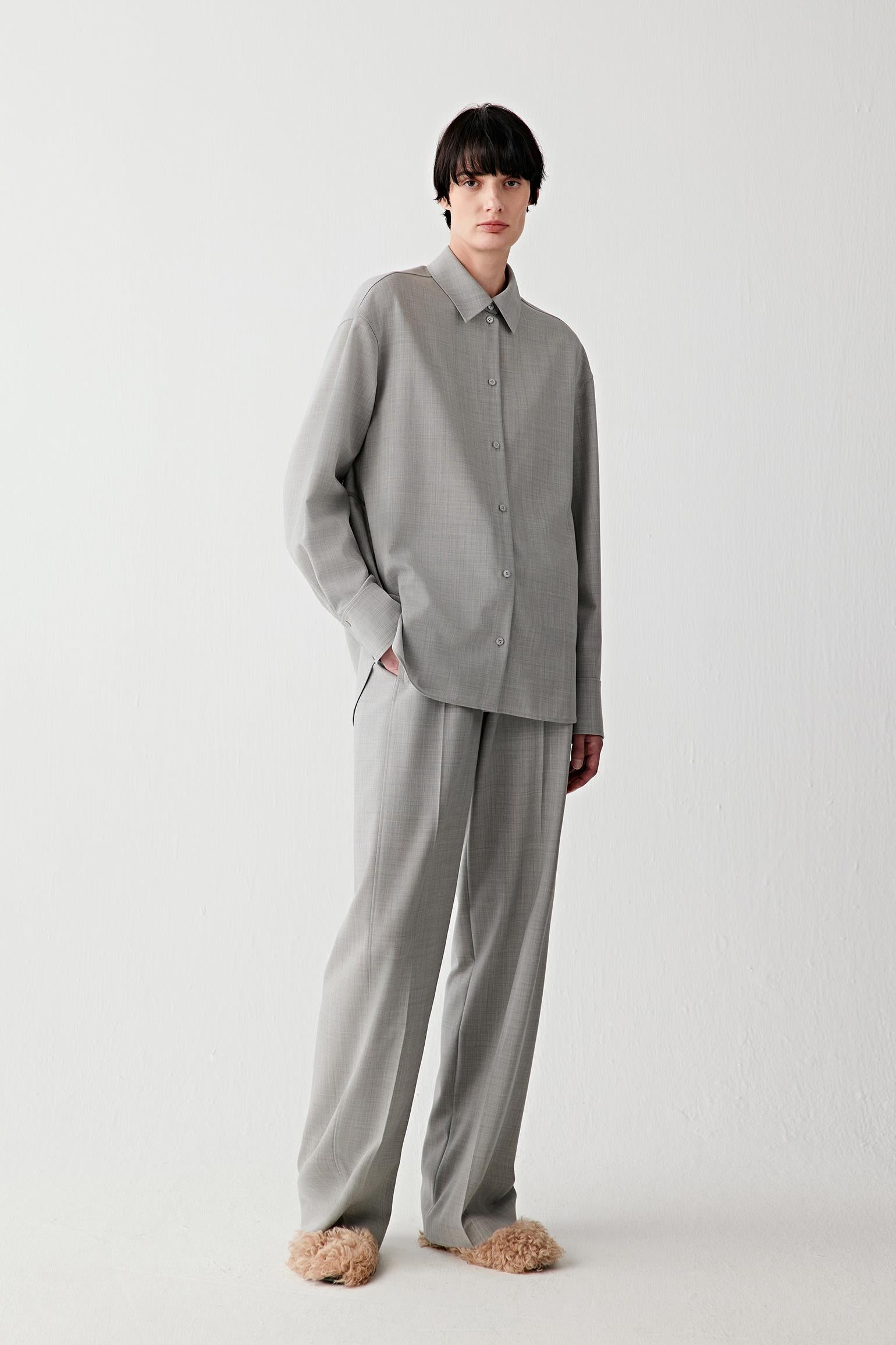Woman wearing a light grey twist wool shirt with matching trousers, full-length front view.