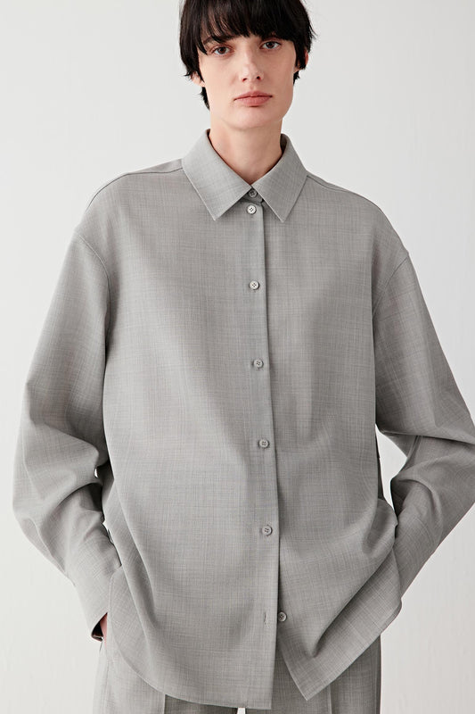 Woman wearing a light grey twist wool shirt with matching trousers, full-length front view.