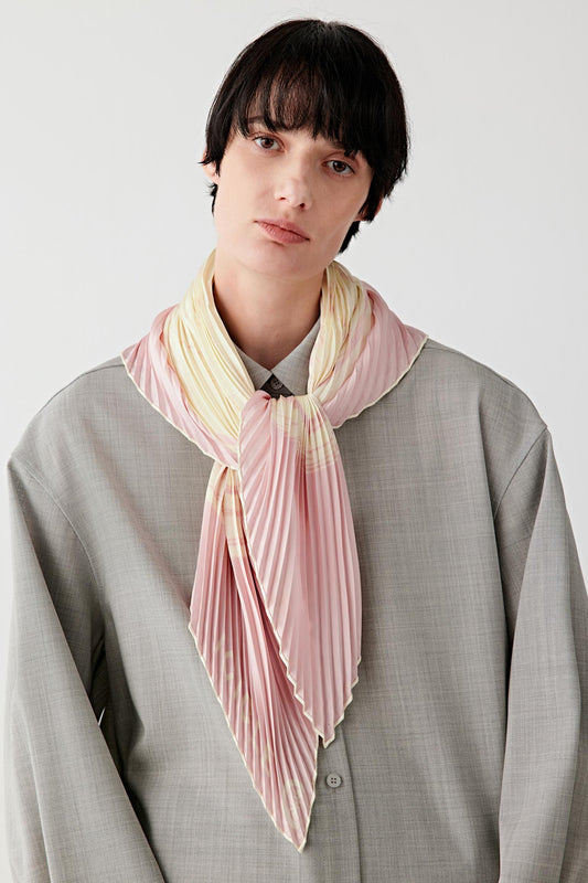 Front view of a striped silk twill scarf worn loosely around the neck, showing soft folds and light pink tonal stripes.