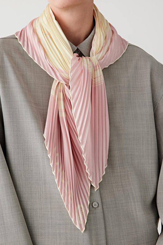 Three-quarter view of the silk twill scarf worn over the shoulders, highlighting the pleated effect and fluid movement.