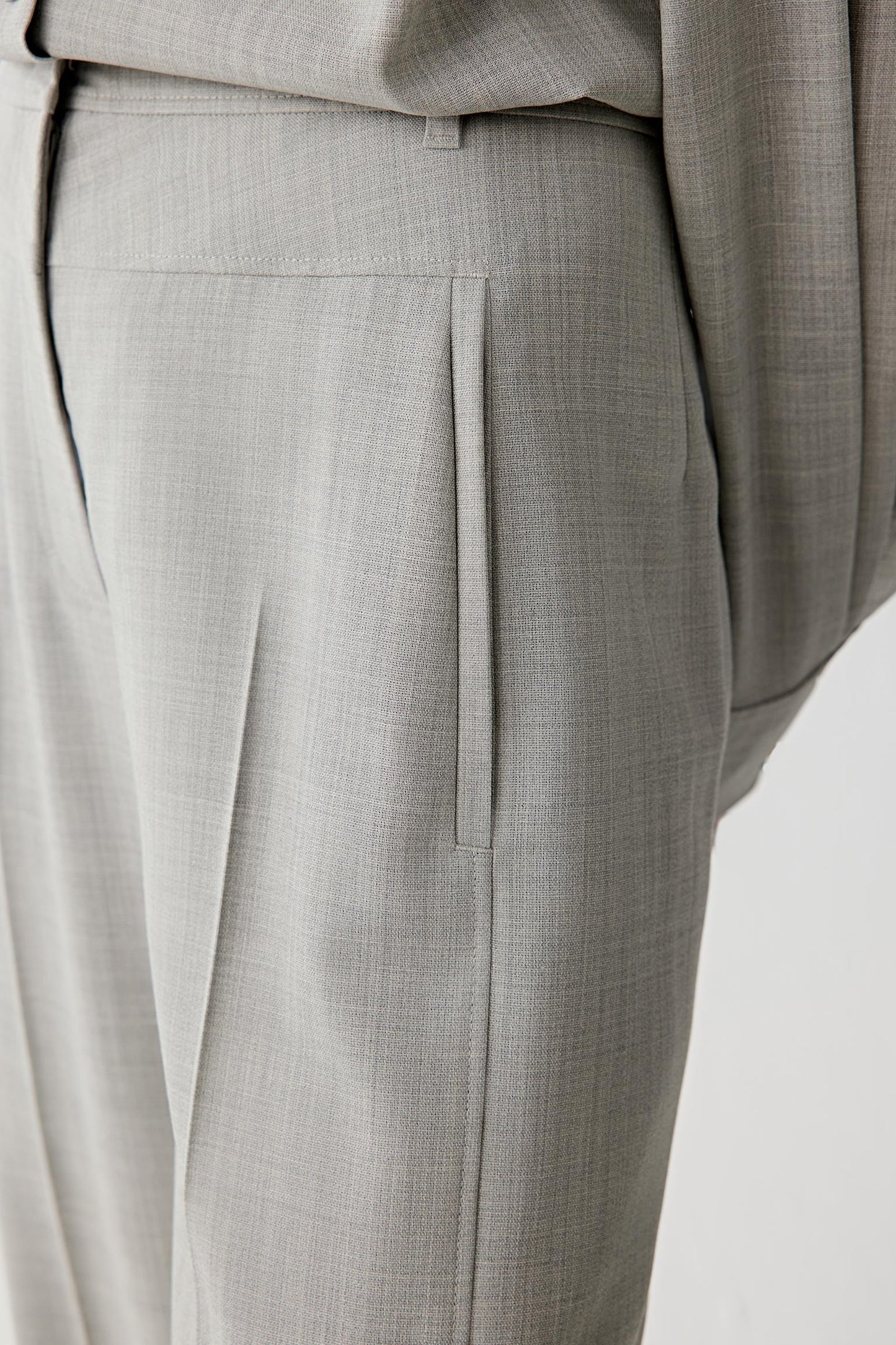 Close-up of the waistband and front pleat detailing.