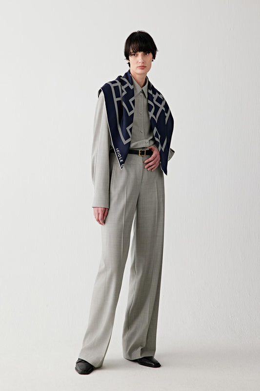 Woman wearing light grey straight-leg twist wool trousers styled with a patterned jacket, full-length view.