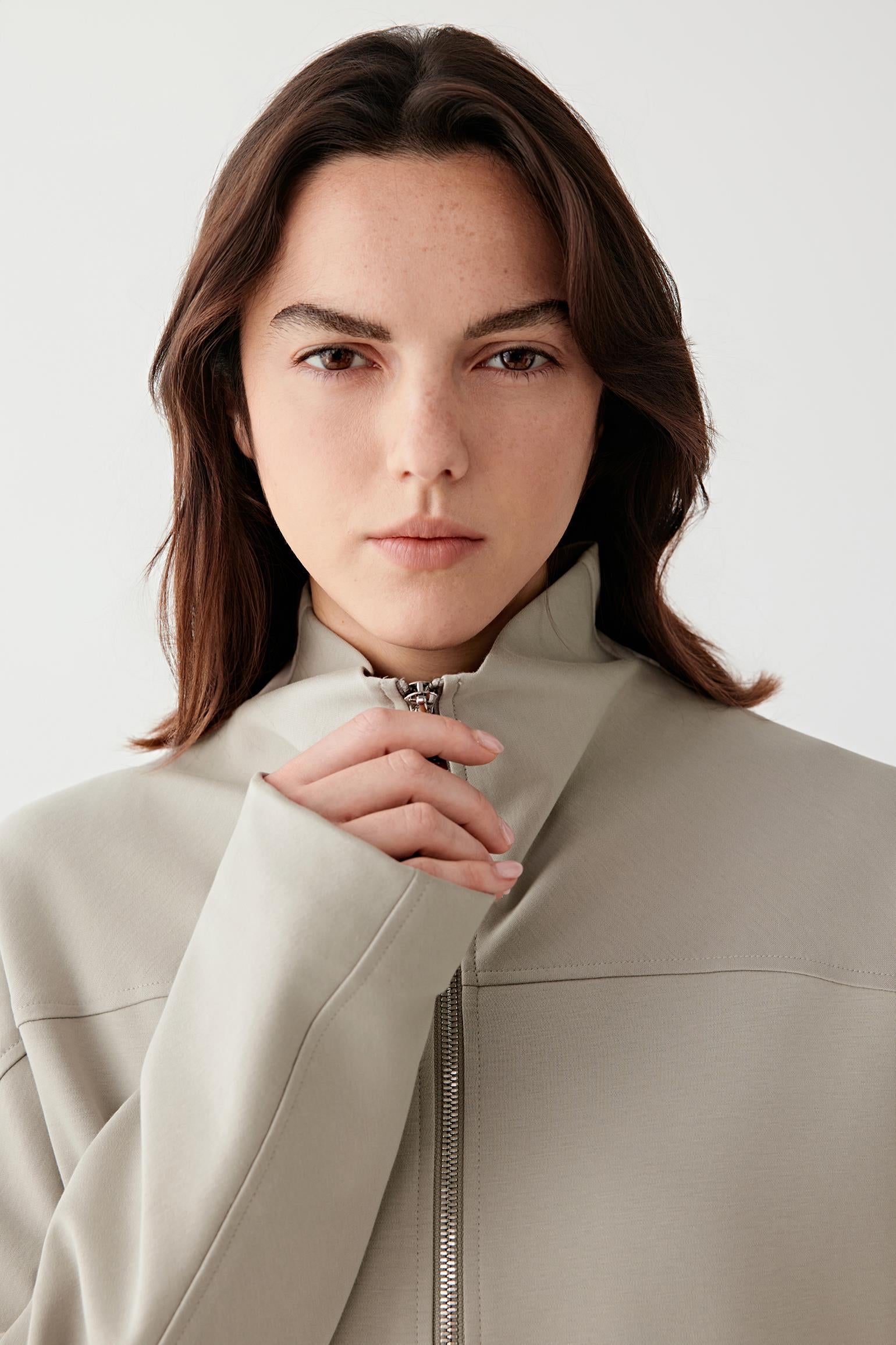 Close-up of the collar and upper front, revealing the smooth jersey texture and minimal finishing.