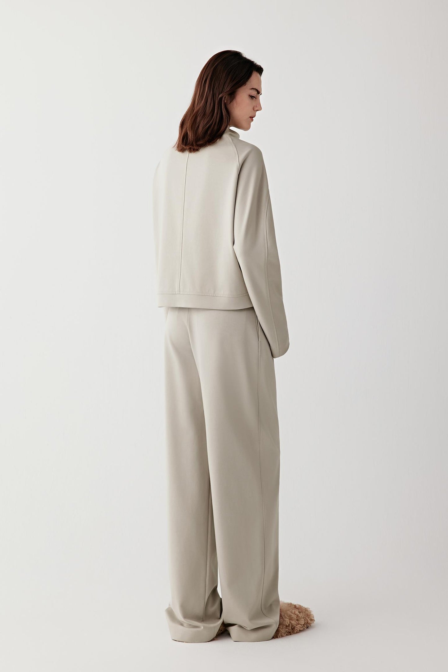 Back view of the short jacket, showing clean lines and a softly structured silhouette.