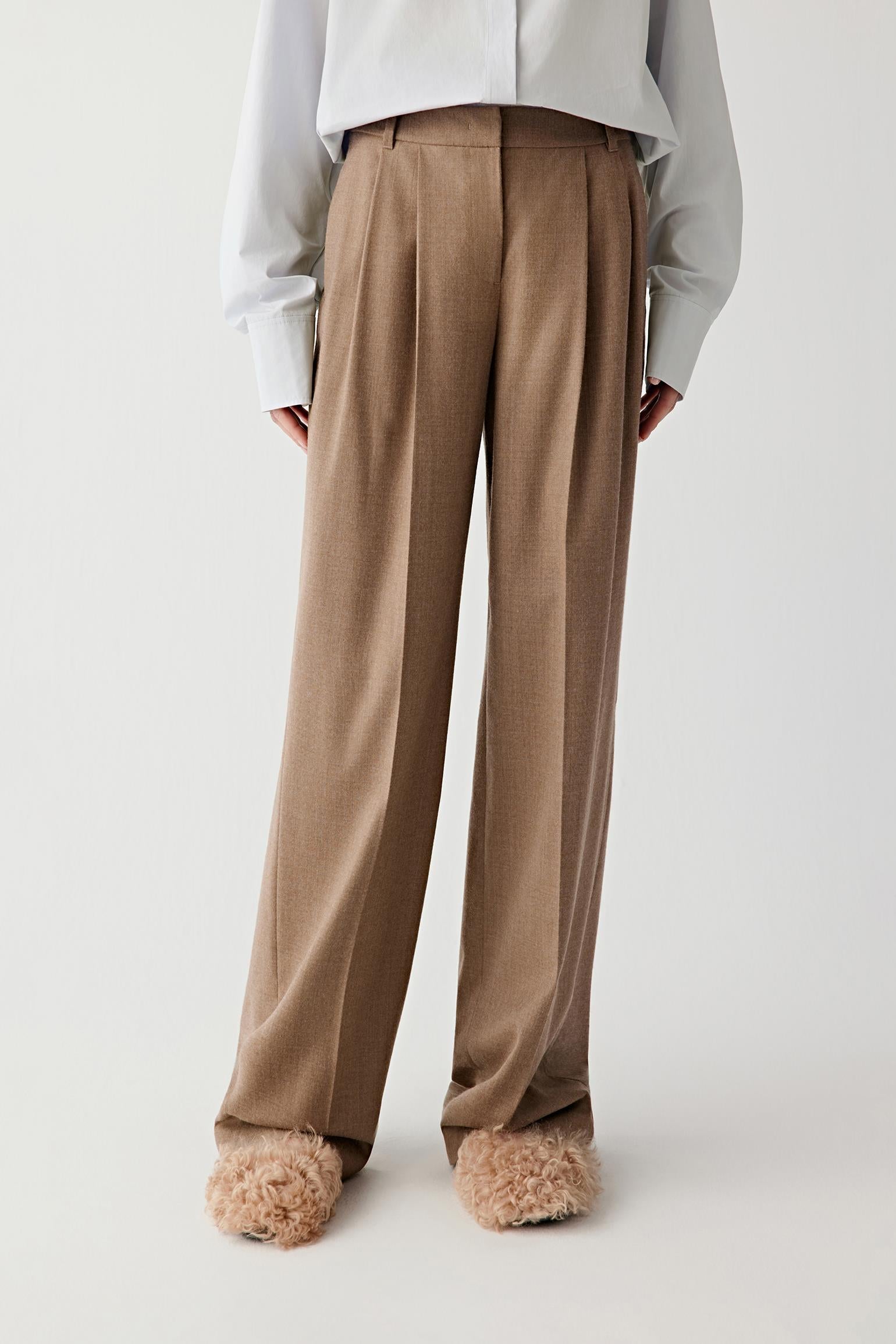 Three-quarter front view emphasizing the elongated leg and fluid drape.