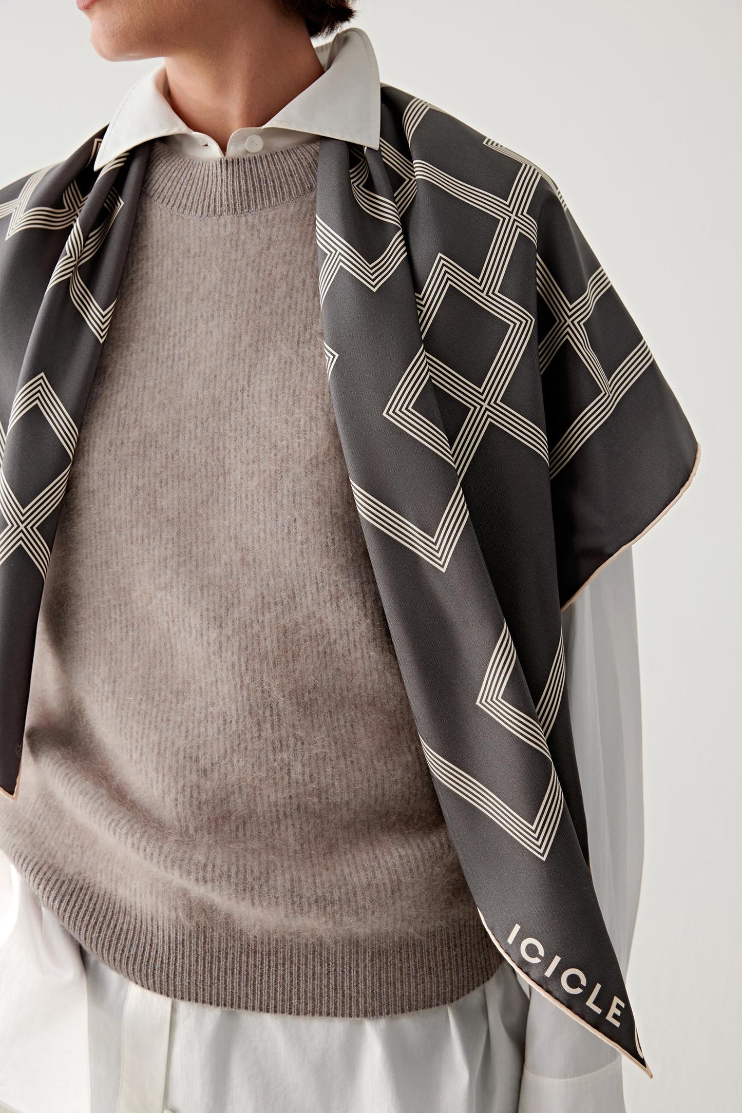 Woman wearing the scarf wrapped loosely around the shoulders.