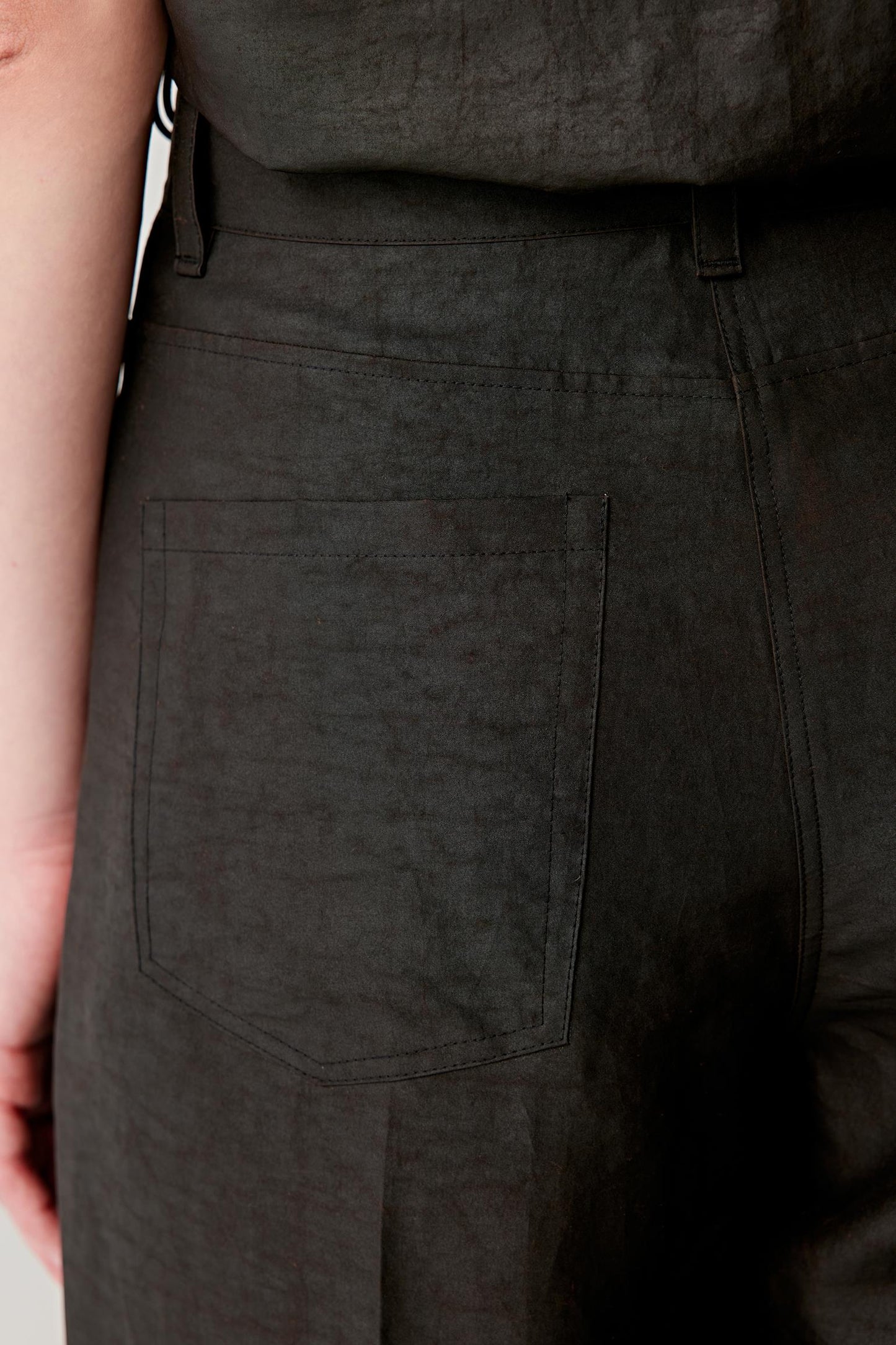 Close-up of the fabric and side area, focusing on the textured surface of the Gambiered Canton gauze, revealing the depth of the black shade, the natural variations from the dyeing process and the fine grain of the fabric