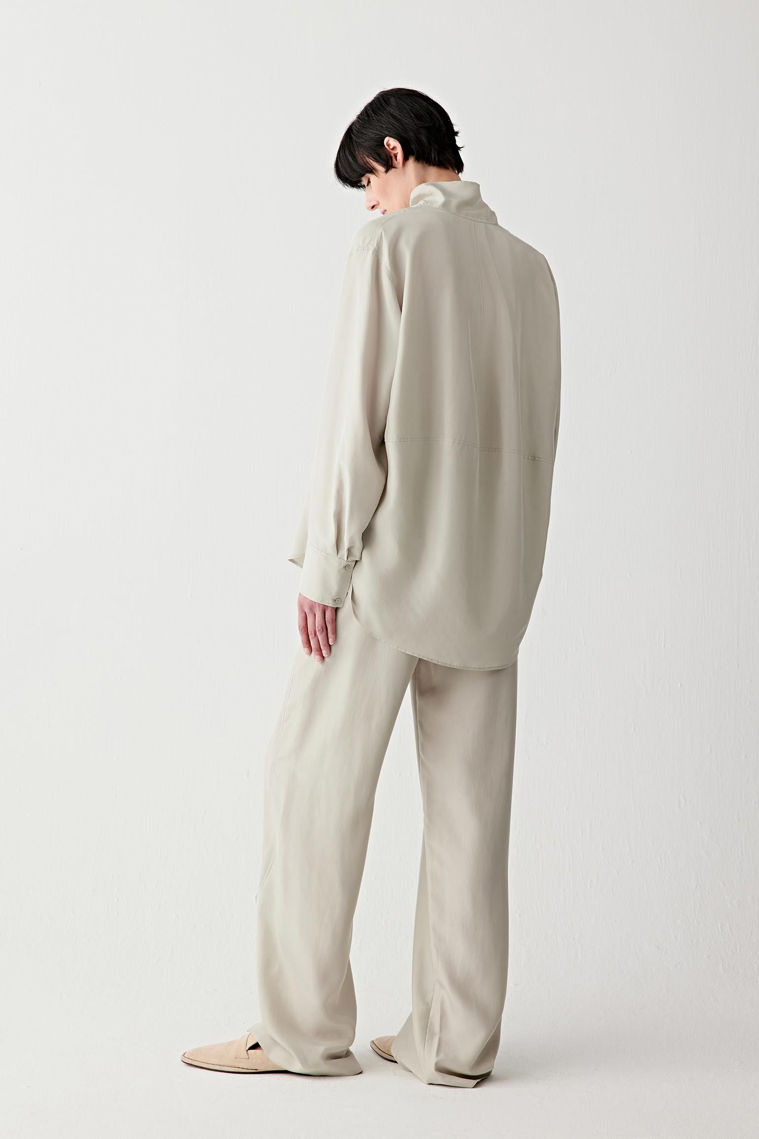 Full-length back view showing the rear silhouette, highlighting the straight cut, the fluid fall across the back and the soft, natural movement of the silk fabric