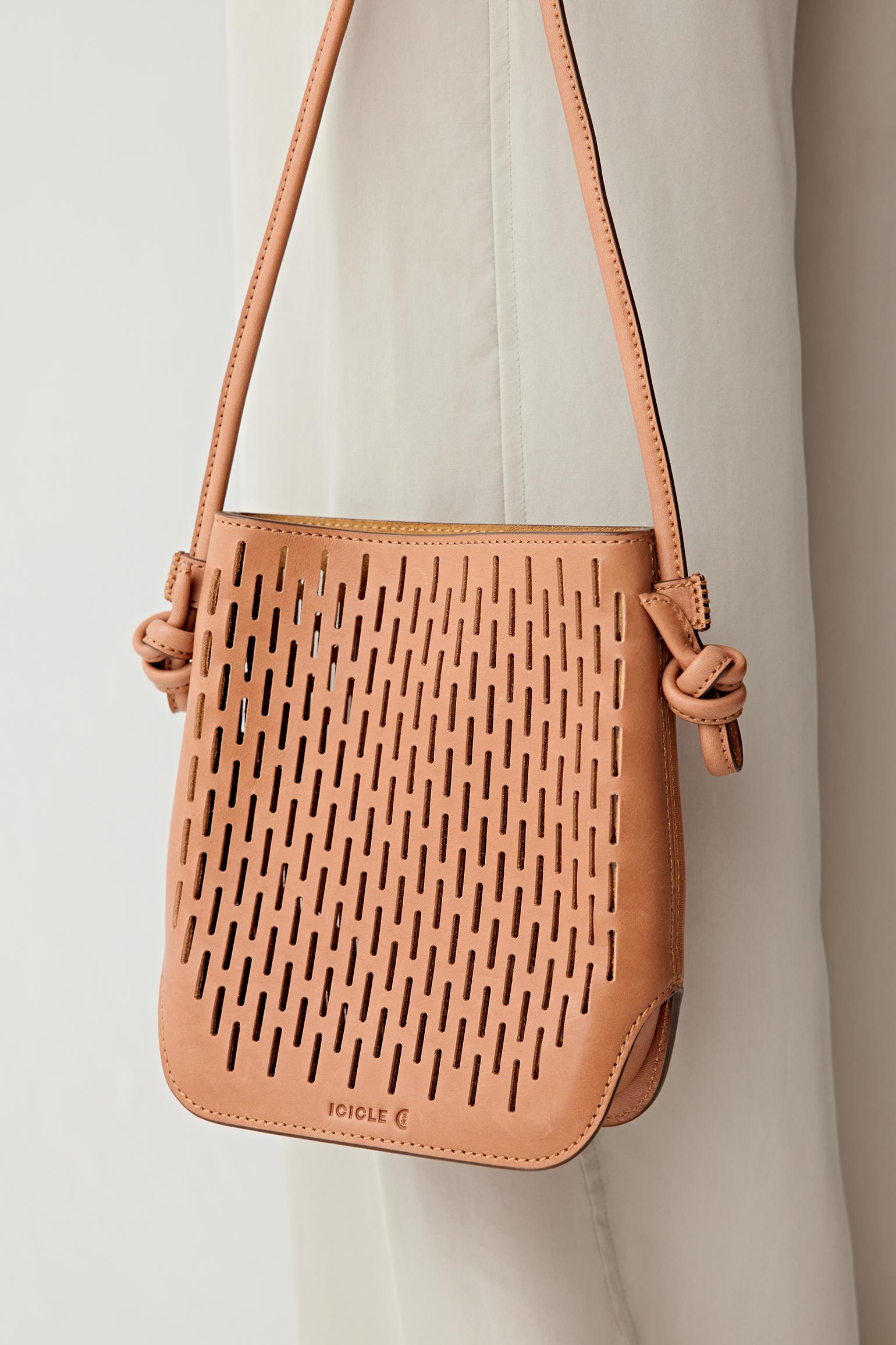 Front view of the camel perforated leather crossbody bag, highlighting the regular mesh pattern, flat base and structured silhouette.