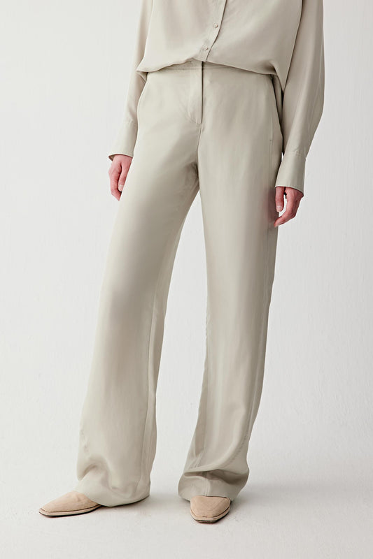 Mid-length front view focusing on the trousers from waist to hem, emphasizing the straight cut, the clean vertical fall and the subtle sheen characteristic of silk habotai