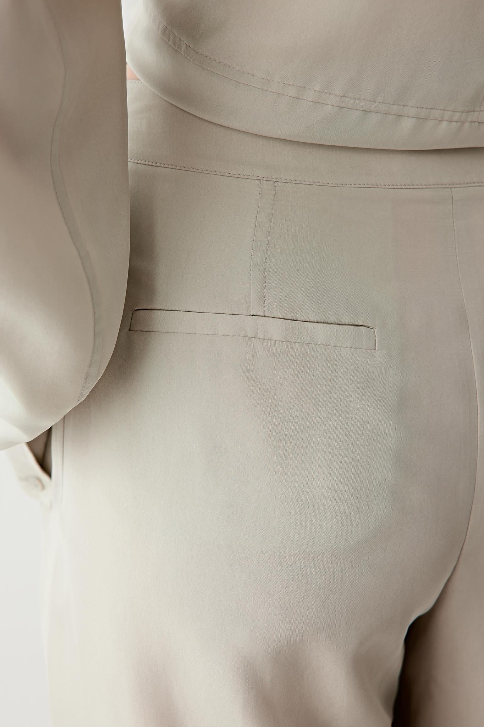 Close-up of the hip and upper thigh area, focusing on the fabric surface, showing the smooth texture, soft sheen and the way the material falls without stiffness
