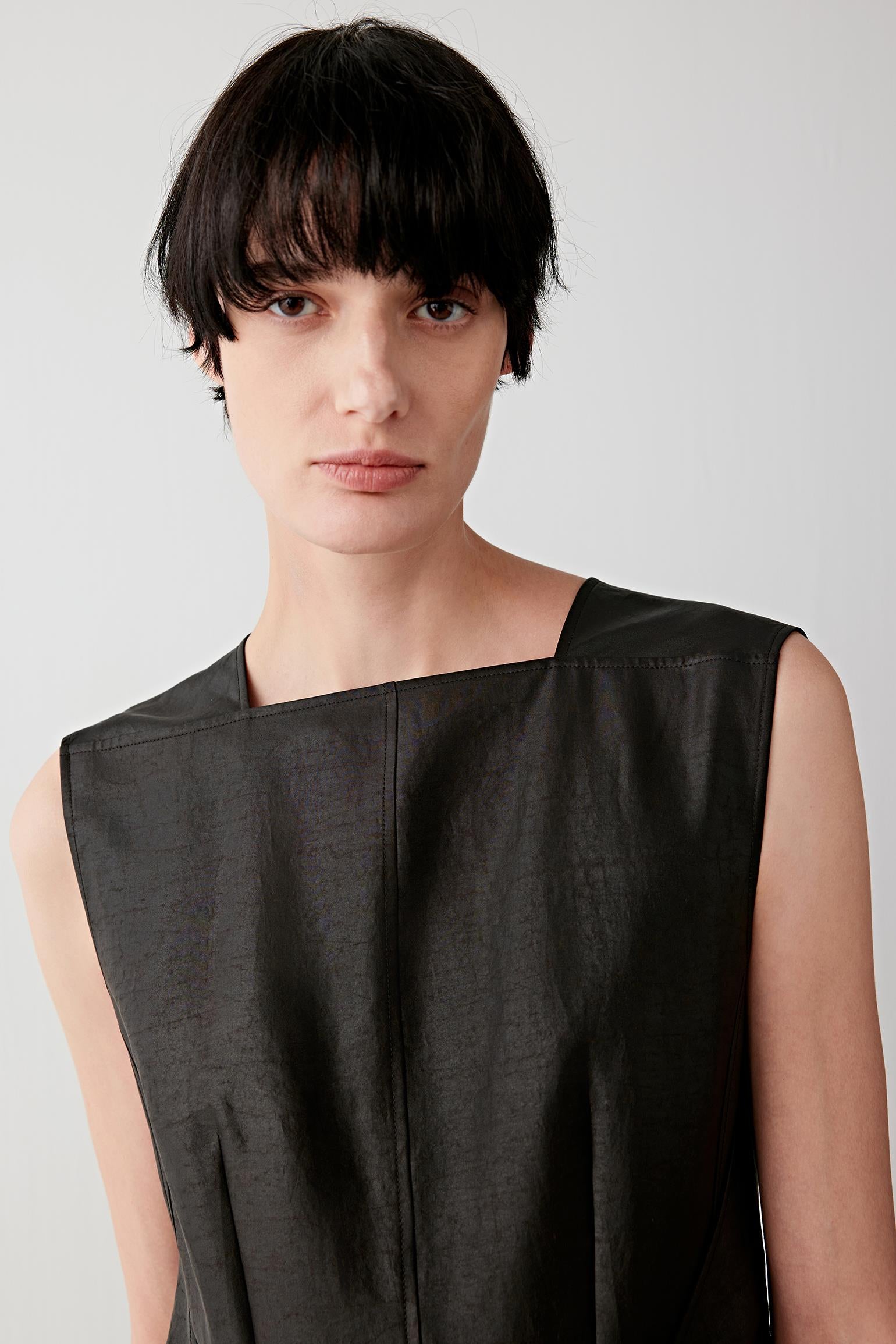 Close-up portrait showing neckline, armhole cut and slightly textured surface of the fabric