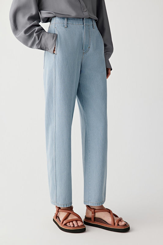 Side view highlighting the relaxed silhouette and the natural fall of the denim fabric from the hips toward the hem.