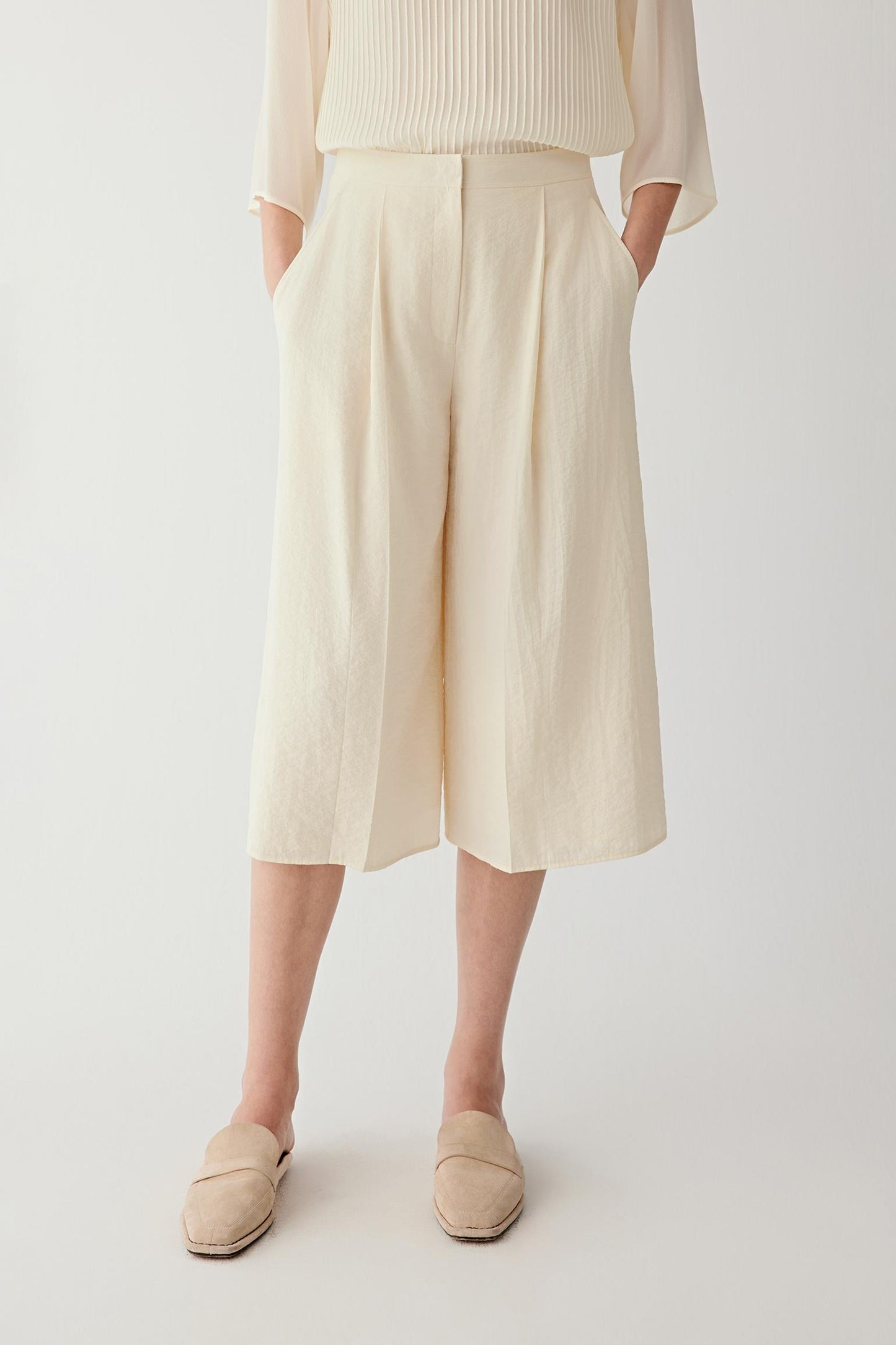 Front or three-quarter view emphasizing the straight silhouette, flat waistband and front pleats, showing the structured fall of the seersucker fabric