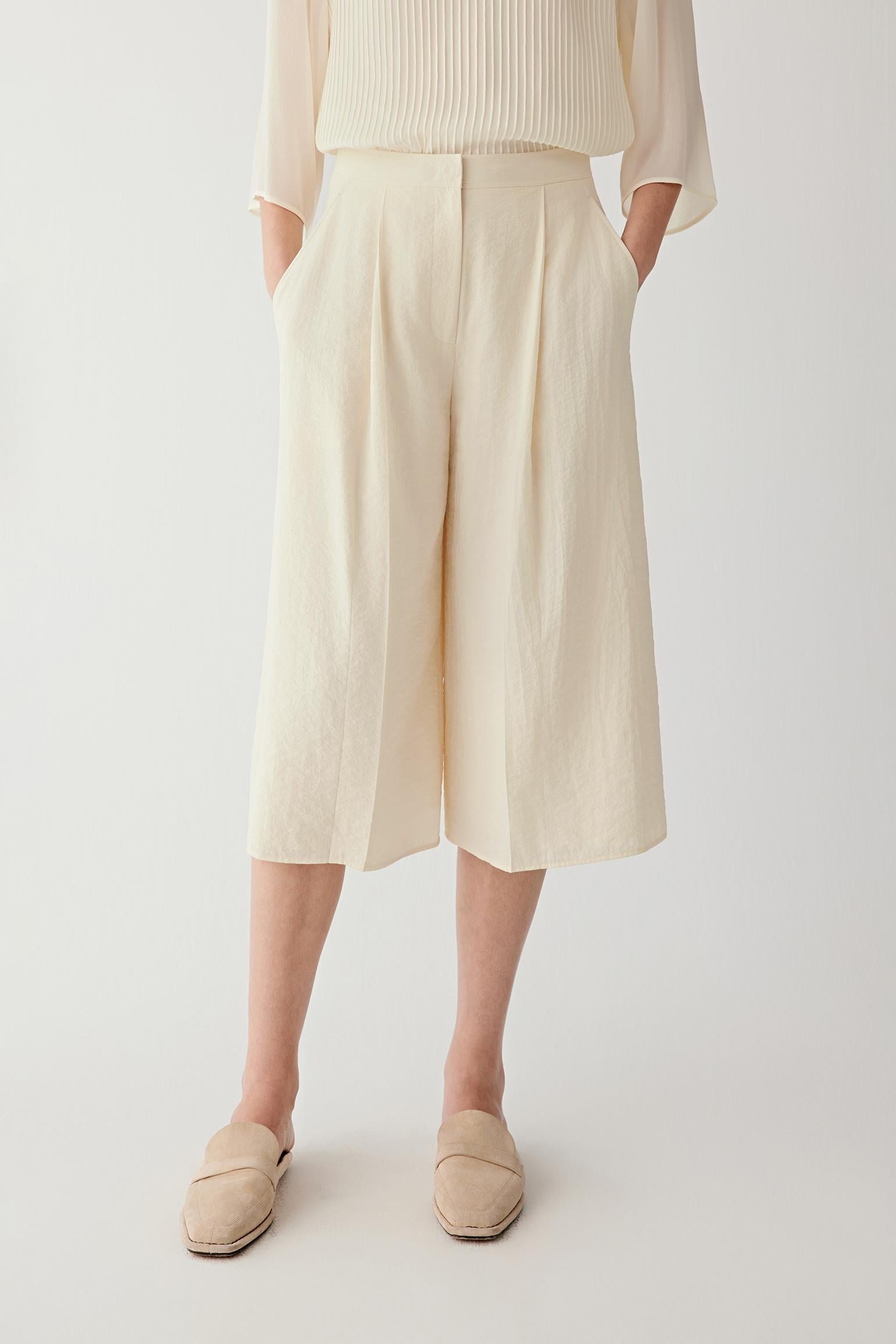 Front or three-quarter view emphasizing the straight silhouette, flat waistband and front pleats, showing the structured fall of the seersucker fabric