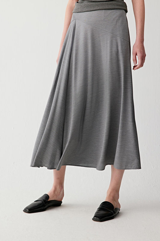 Front or three-quarter view emphasizing the fitted waistband and softly flared shape, showing the fluid movement of the stretch jersey construction