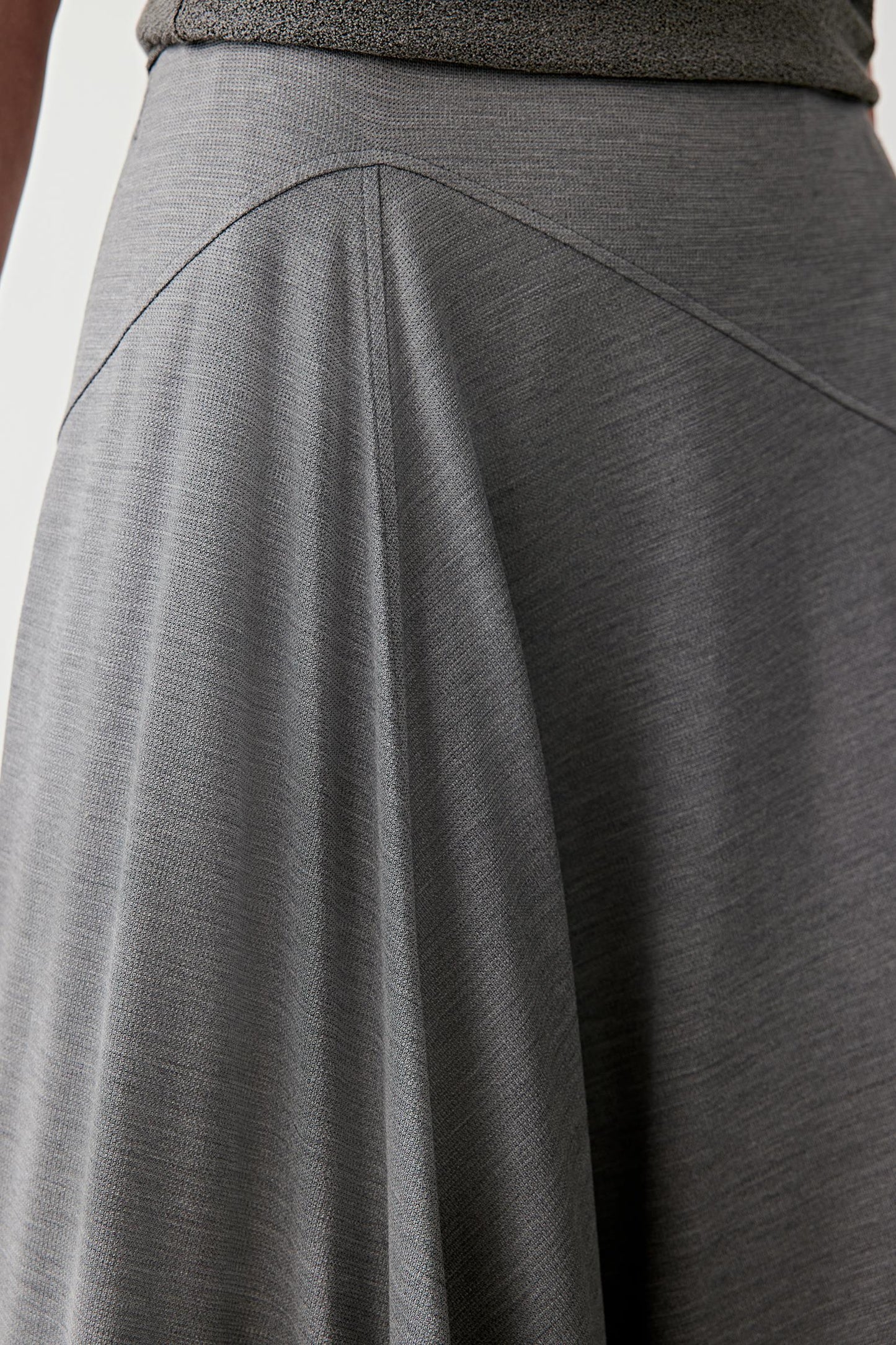 Close-up of diagonal seam construction detailing the panel lines, fluid jersey texture and subtle melange effect