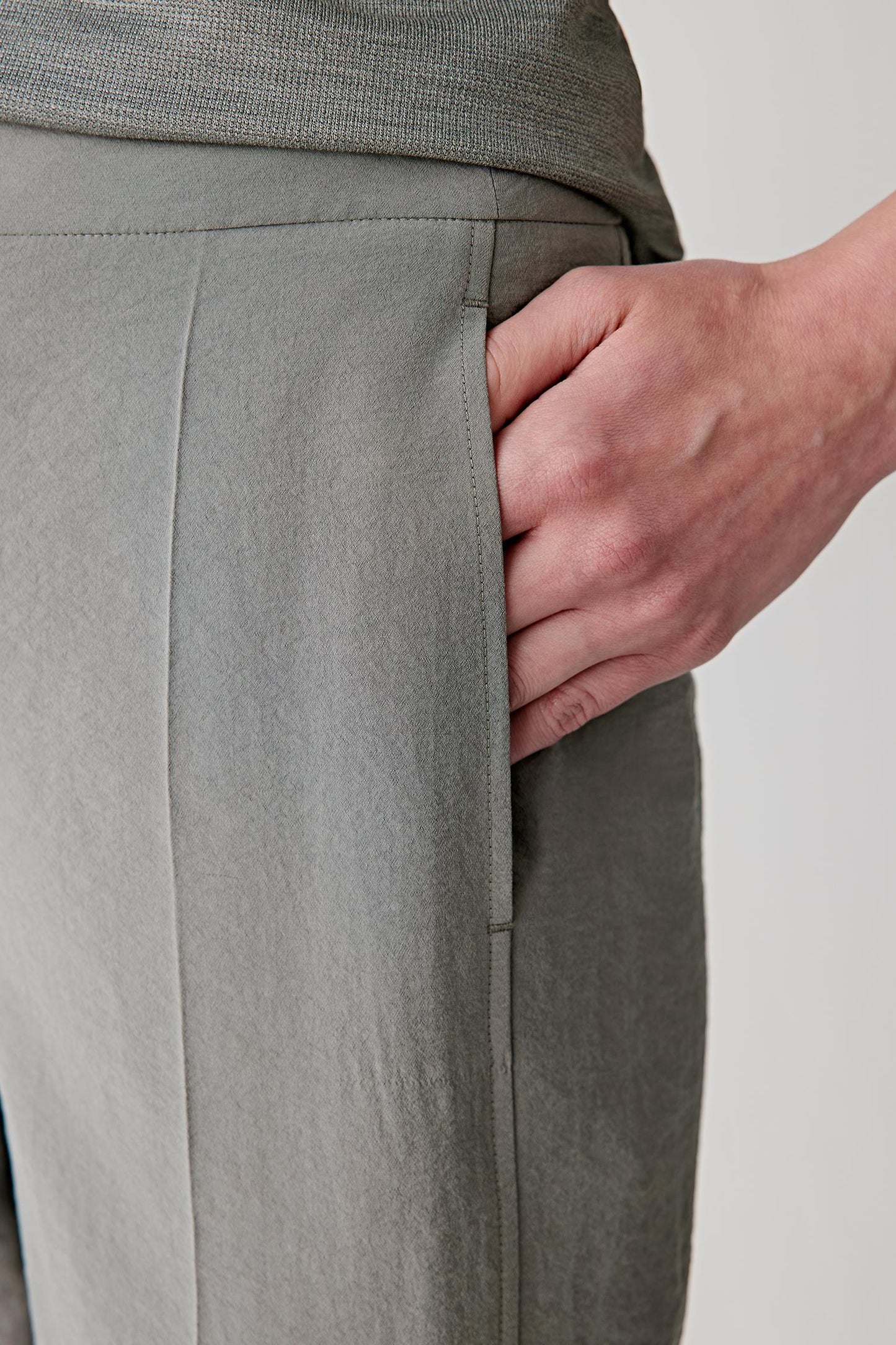 Close-up of pressed crease and waistband detailing the structured construction, subtle texture and matte finish of the seersucker weave