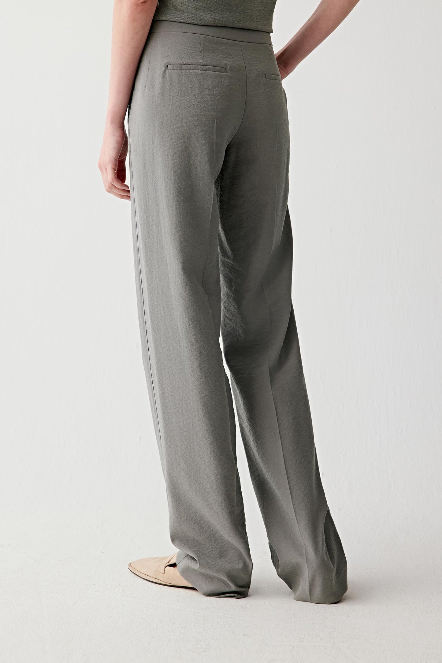 Full-length side or back view highlighting the elongated line and lightweight texture through the trousers