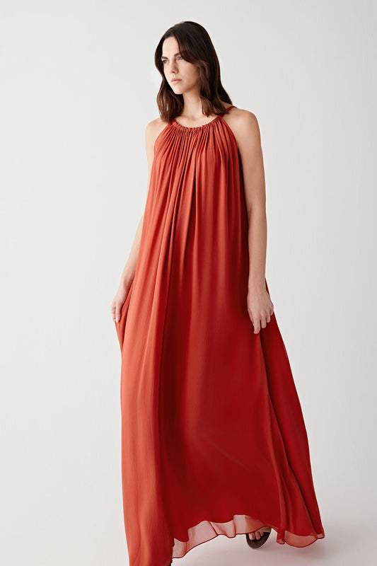 Full-length front view showing the elongated sleeveless silhouette and softly gathered neckline construction. The silk mousseline falls fluidly through the body, creating soft volume and continuous movement.