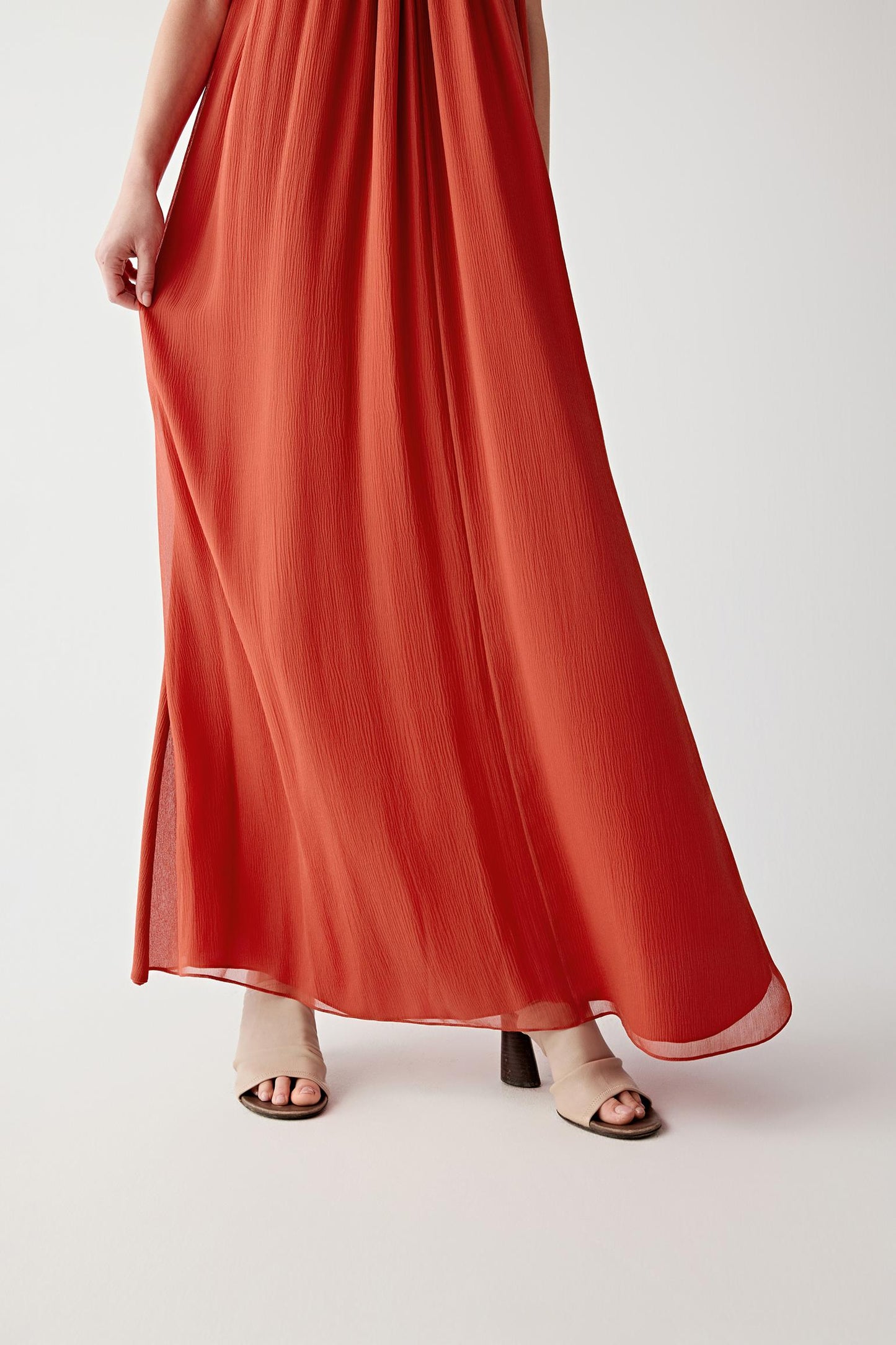 Close-up of the fabric and hem movement showing the airy silk surface, fluid transparency and layered drape characteristic of silk mousseline.
