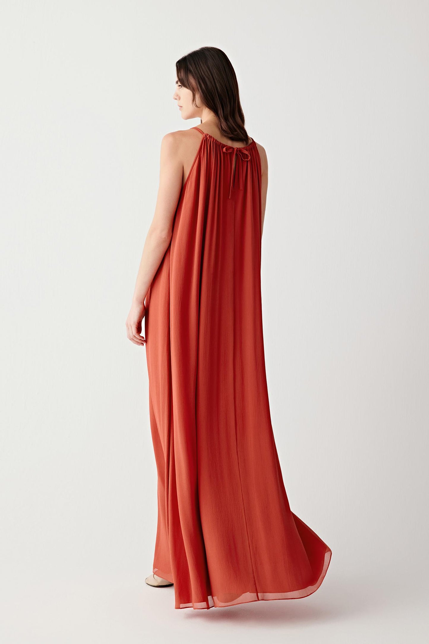 Side or back view emphasizing the airy structure and flowing movement of the lightweight silk fabric. The elongated silhouette maintains a soft and uninterrupted line.