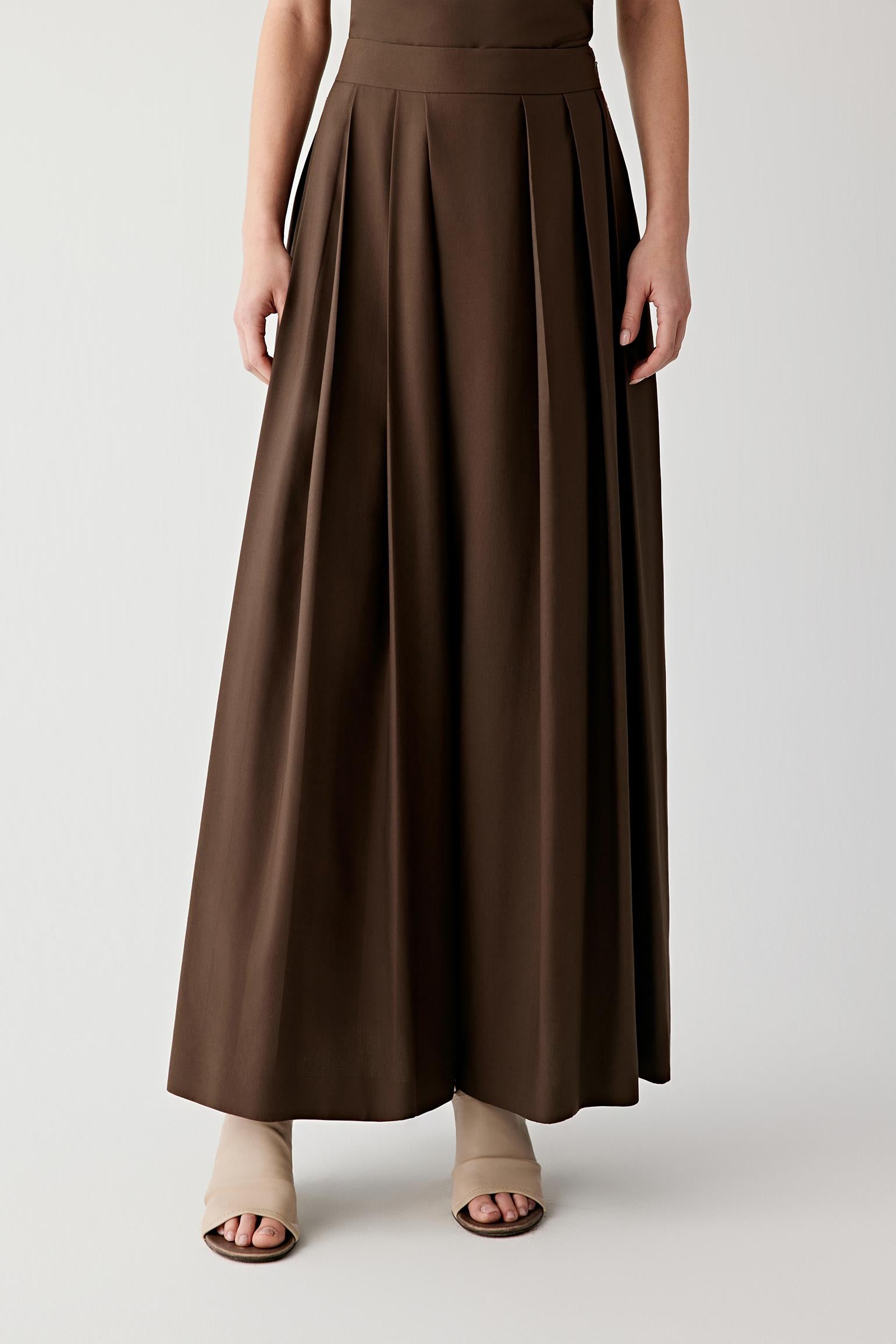Full-length view focused on the trousers, emphasizing the fluid fall of the spun silk poplin from the waistband to the hem. The dense yet lightweight fabric creates a continuous line with subtle movement and refined structure.