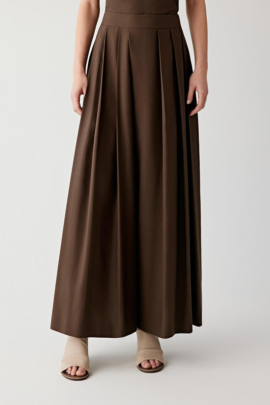 Full-length view focused on the trousers, emphasizing the fluid fall of the spun silk poplin from the waistband to the hem. The dense yet lightweight fabric creates a continuous line with subtle movement and refined structure.