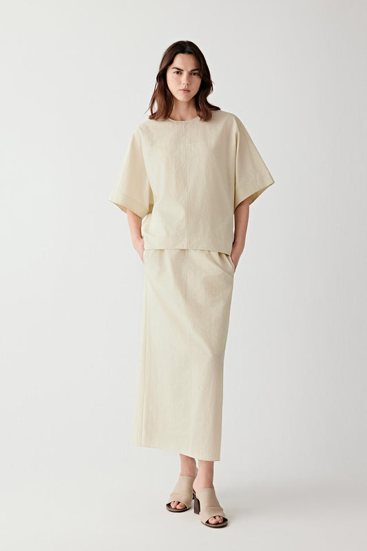 Full-length front view showing the relaxed silhouette and wide short sleeves, emphasizing the airy structure and movement of the crinkled fabric