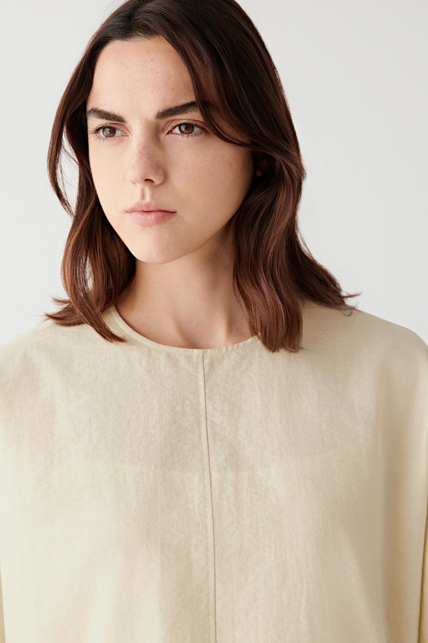 Close-up of seam and fabric texture showing the softly irregular crinkled structure, lightweight weave and subtle tonal depth