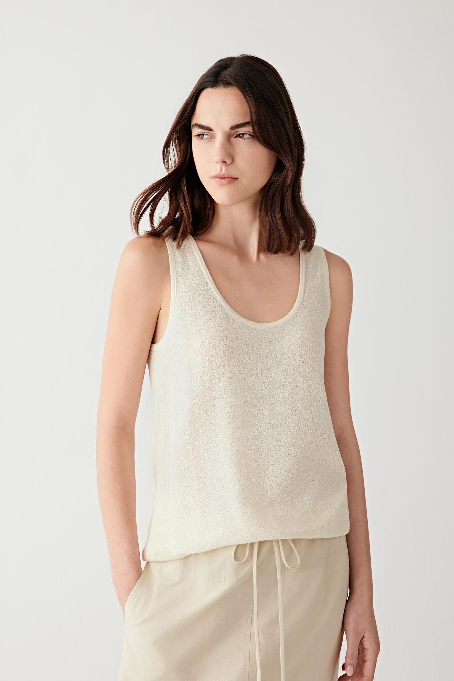 Front or three-quarter view emphasizing the relaxed sleeveless silhouette and round neckline, showing the airy open-textured knit construction
