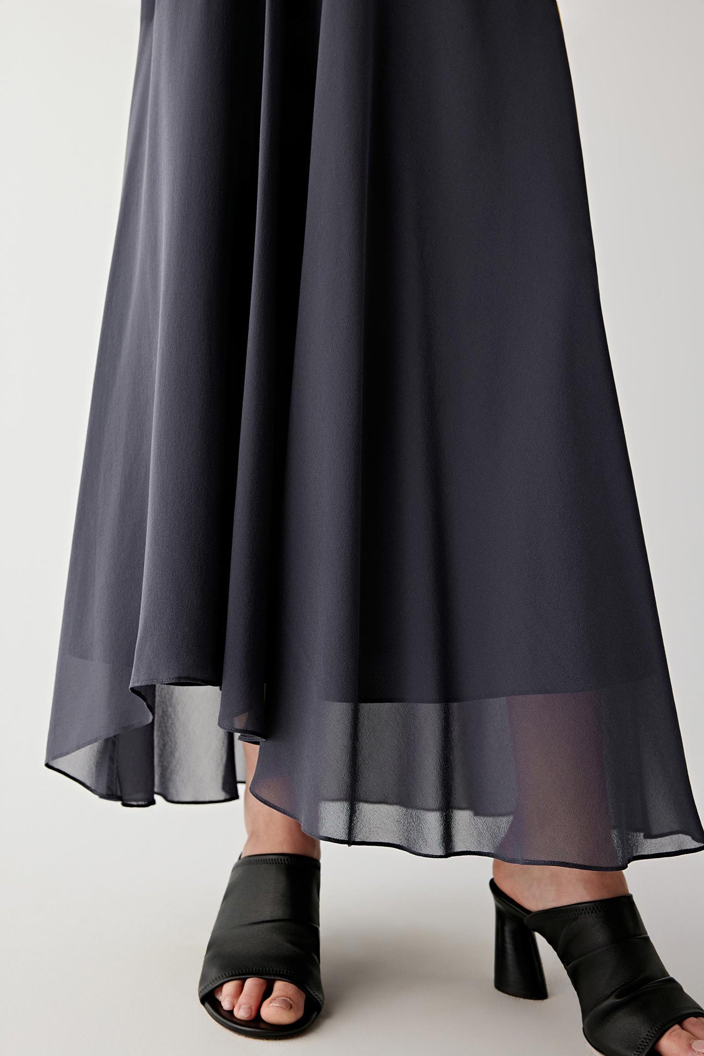 Close-up of hem and fabric texture showing the fine grain of the silk georgette weave, fluid drape and subtle sheerness of the fabric