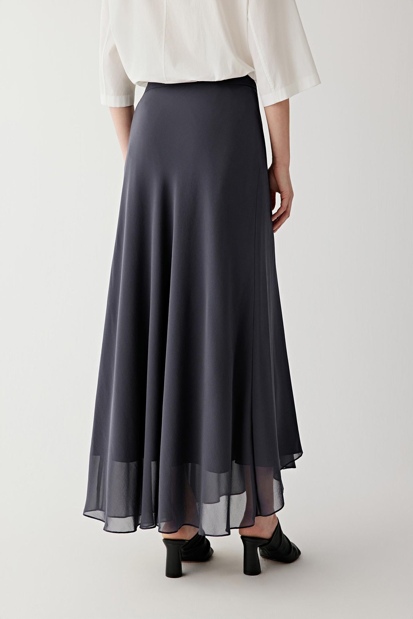Mid-length side or back view highlighting the fluid hem movement and subtle transparency at the hemline