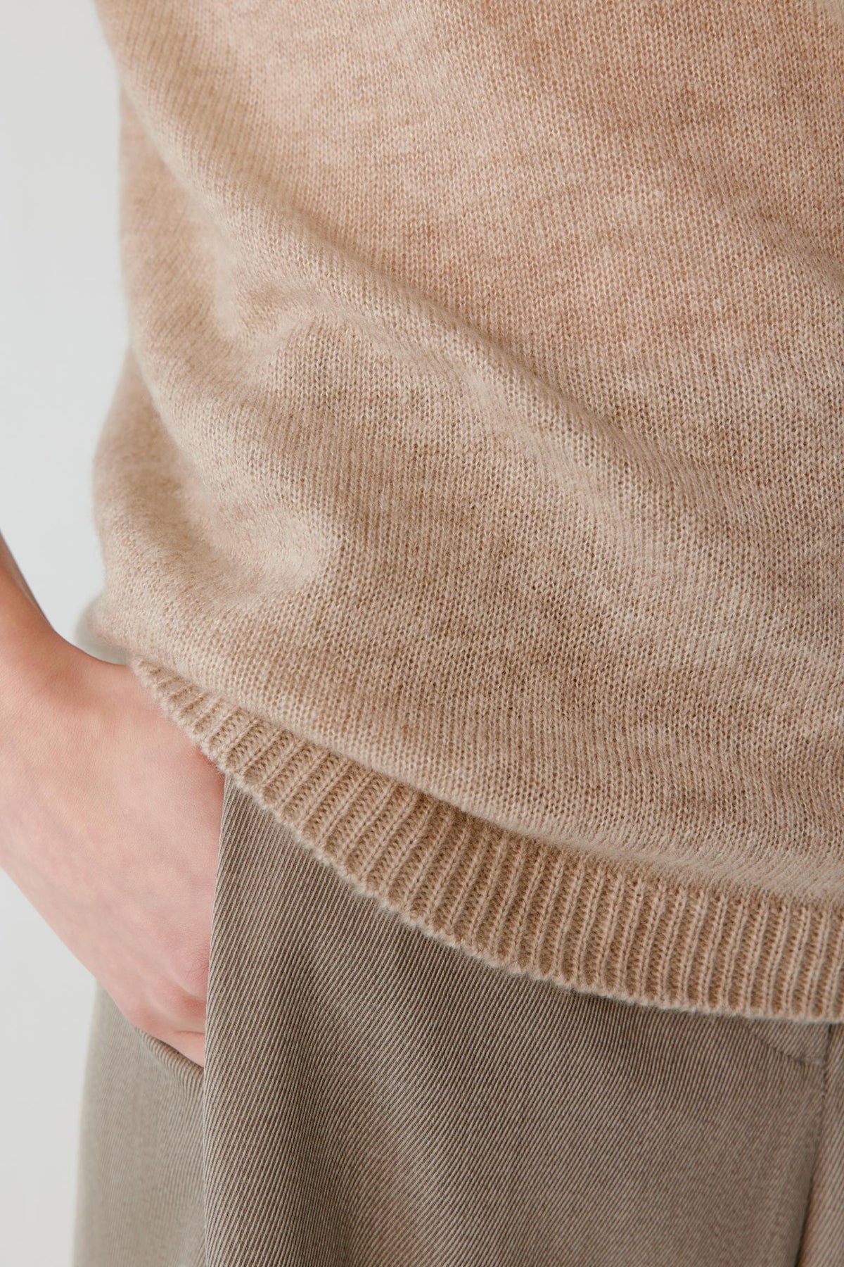 Close-up highlighting the ribbed hem and fine-knit texture of the beige cashmere and silk top.