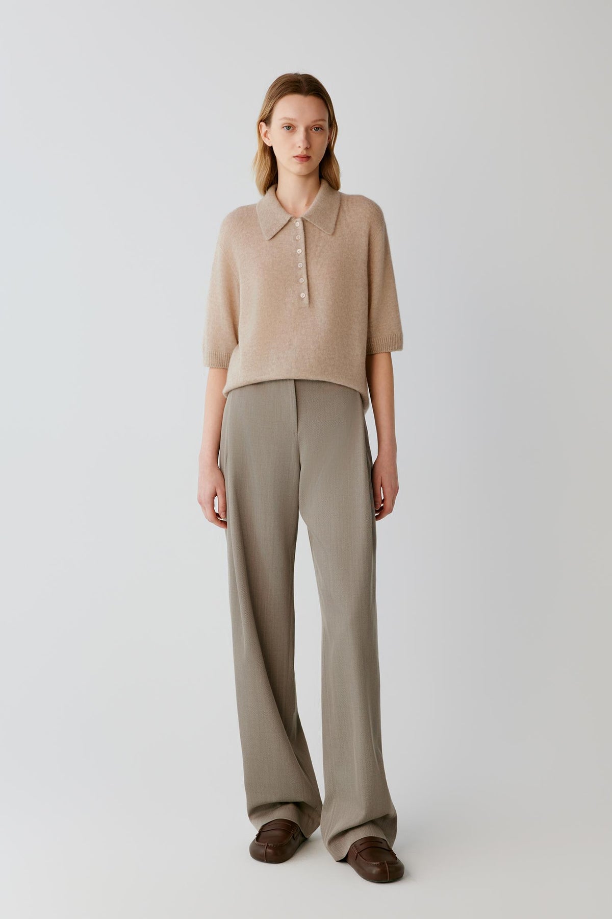 Front full-length view of a woman wearing the beige cashmere and silk top, highlighting the straight silhouette and elbow-length sleeves.