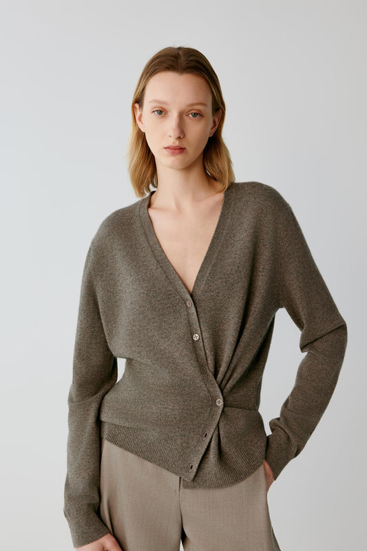 Front view of a woman wearing a taupe cashmere wrap cardigan, showing the V-neckline, asymmetric wrap front and long sleeves.