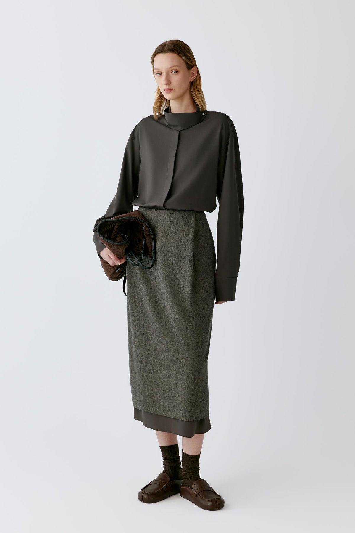 Front view of a woman wearing a walnut brown silk poplin shirt, showing the stand collar, long sleeves and fluid silhouette.