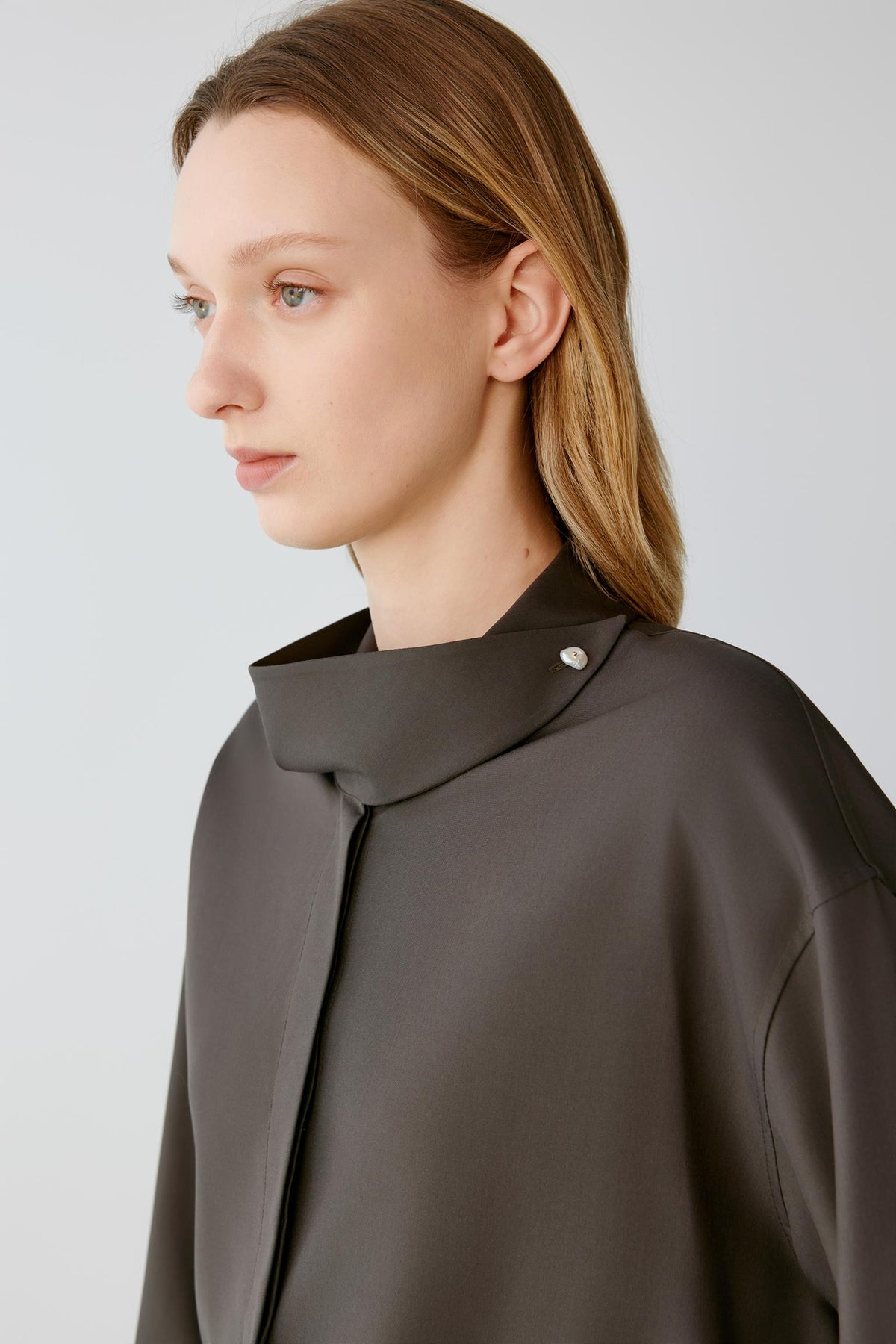 Close-up highlighting the stand collar, decorative button and smooth silk poplin surface.