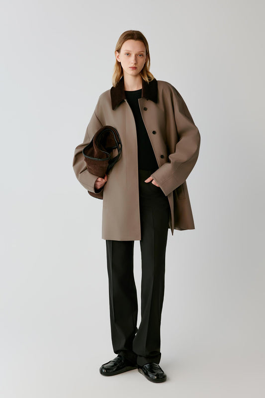 Full-length view highlighting the relaxed cut, dropped shoulders and side welt pockets of the dusty brown short coat.