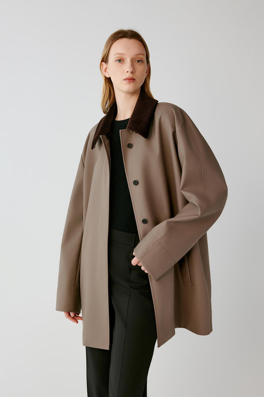 Front view of a woman wearing a dusty brown wool and silk short coat, showing the straight silhouette and contrasting dark brown corduroy collar.