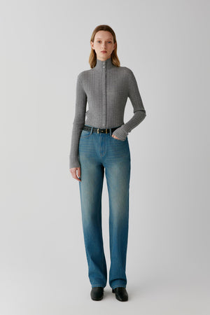 Front view of a woman wearing a grey melange worsted wool cardigan, showing the close-fitting silhouette, stand collar and button-front fastening.