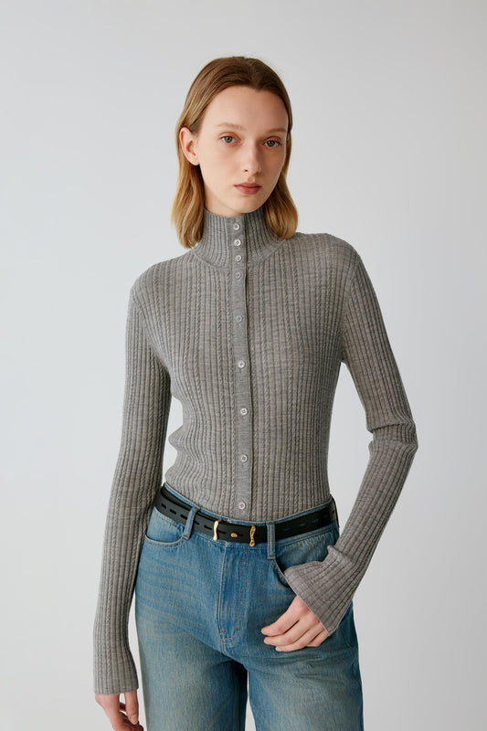 Three-quarter view highlighting the fitted shape, long sleeves and ribbed knit texture of the grey melange worsted wool cardigan.