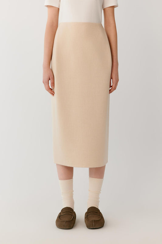 Front view highlighting the midi length, straight cut and smooth surface of the beige melange double-face wool skirt.