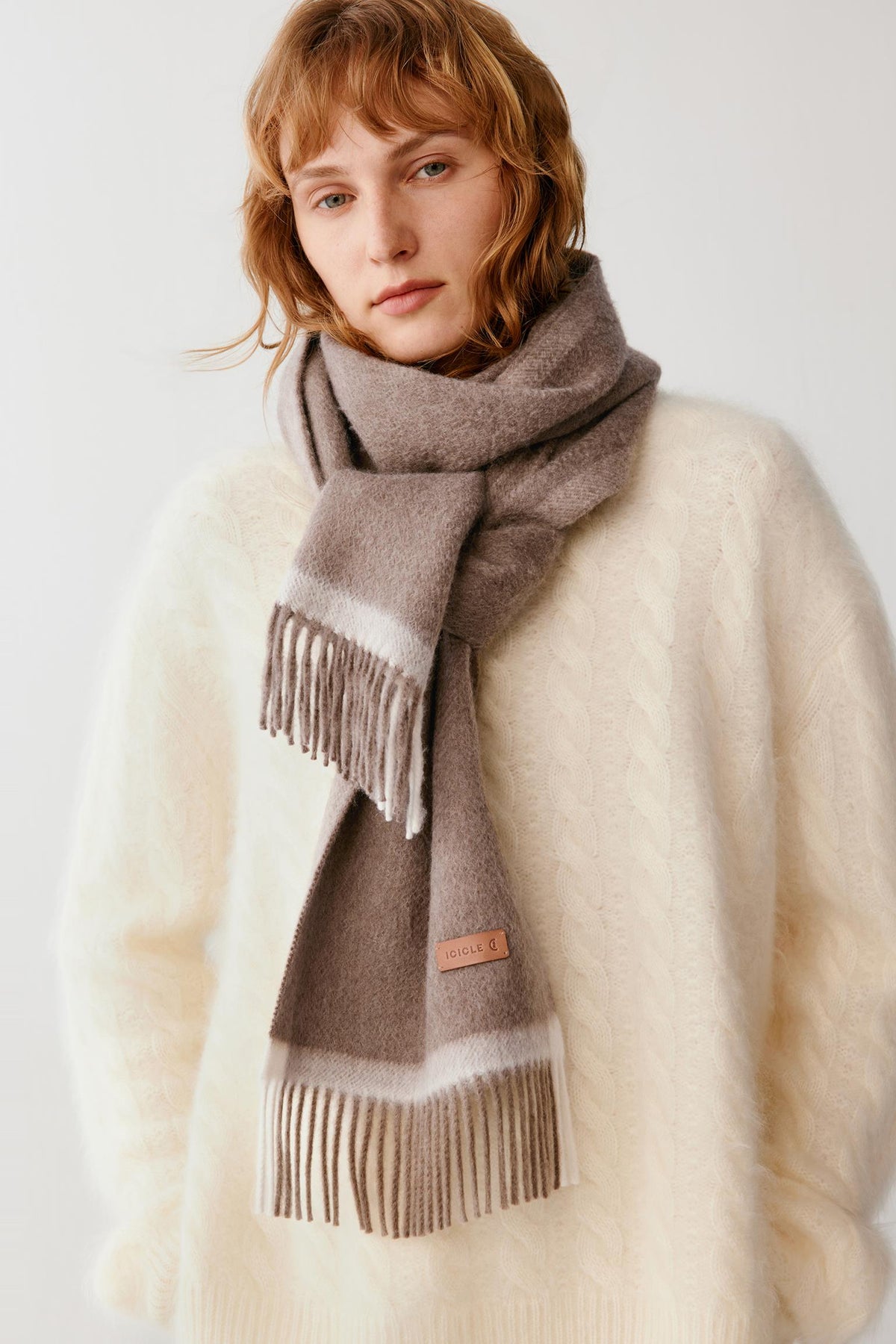 Front view highlighting the dark grey cashmere scarf wrapped around the neck, with contrasting light grey trim and fringed ends.