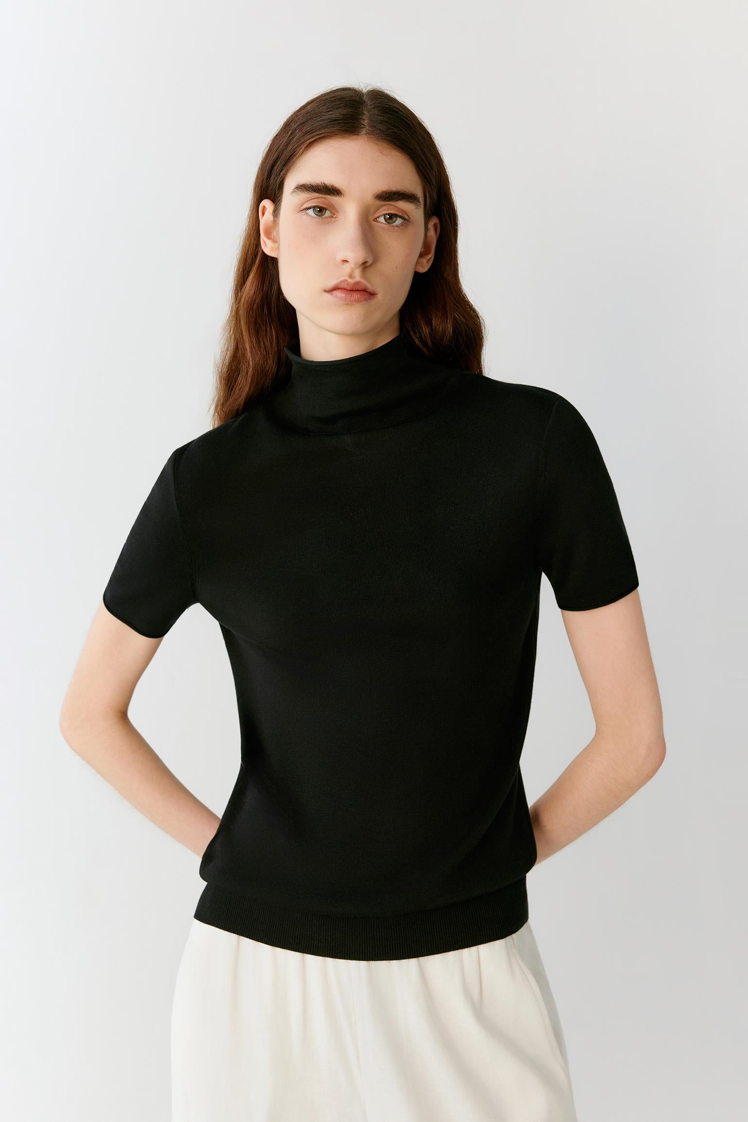 Front view showing the fitted shape and the natural drape of the fine-gauge silk knit. The image emphasizes the mock neckline, fine ribbed finishes and the clean structure of the garment.