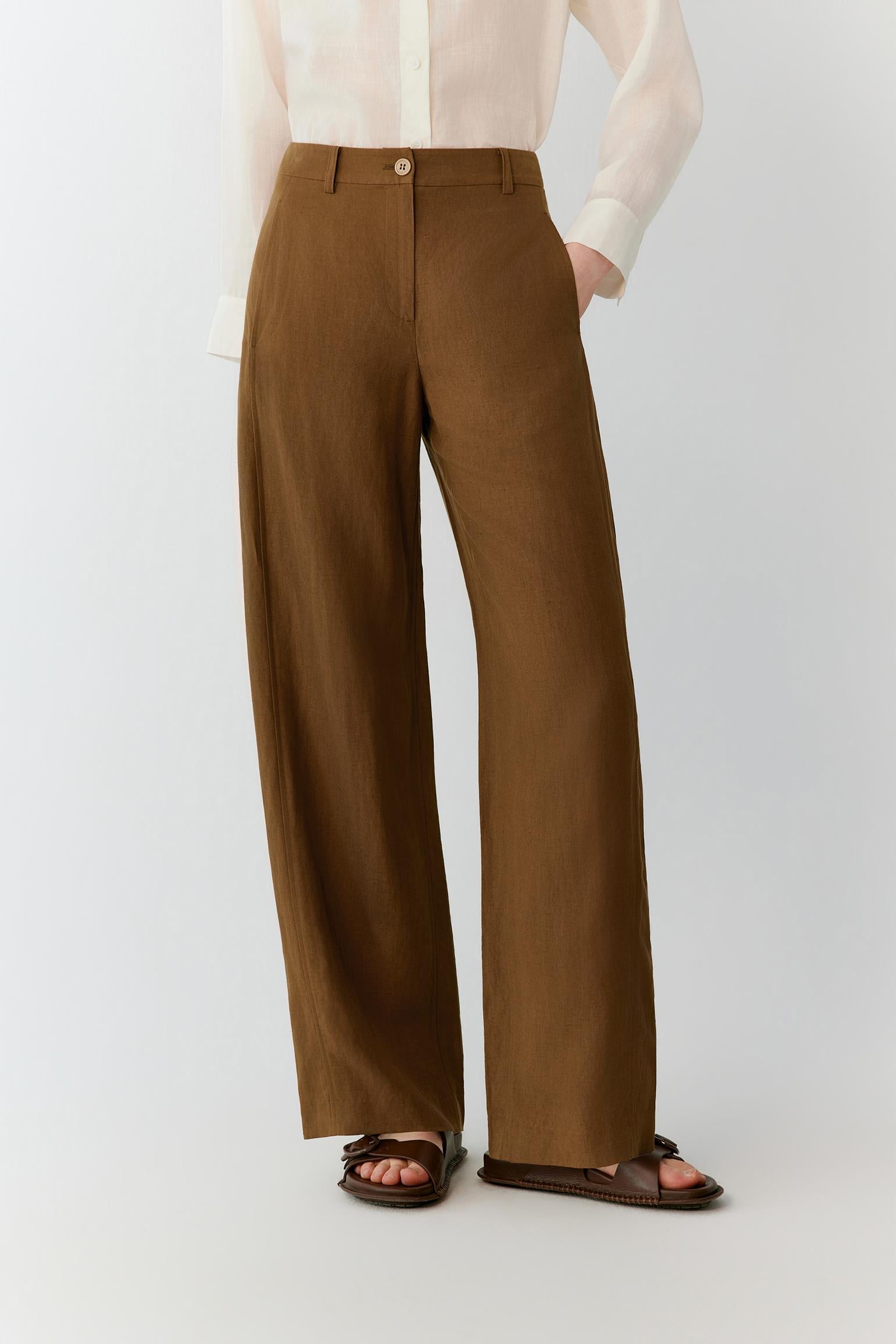 Full-length view focused on the trousers, emphasizing the straight-leg cut, elongated proportions and natural movement of the lightweight silk and linen blend. The image highlights the fluid fall of the fabric from the waistband to the hem.