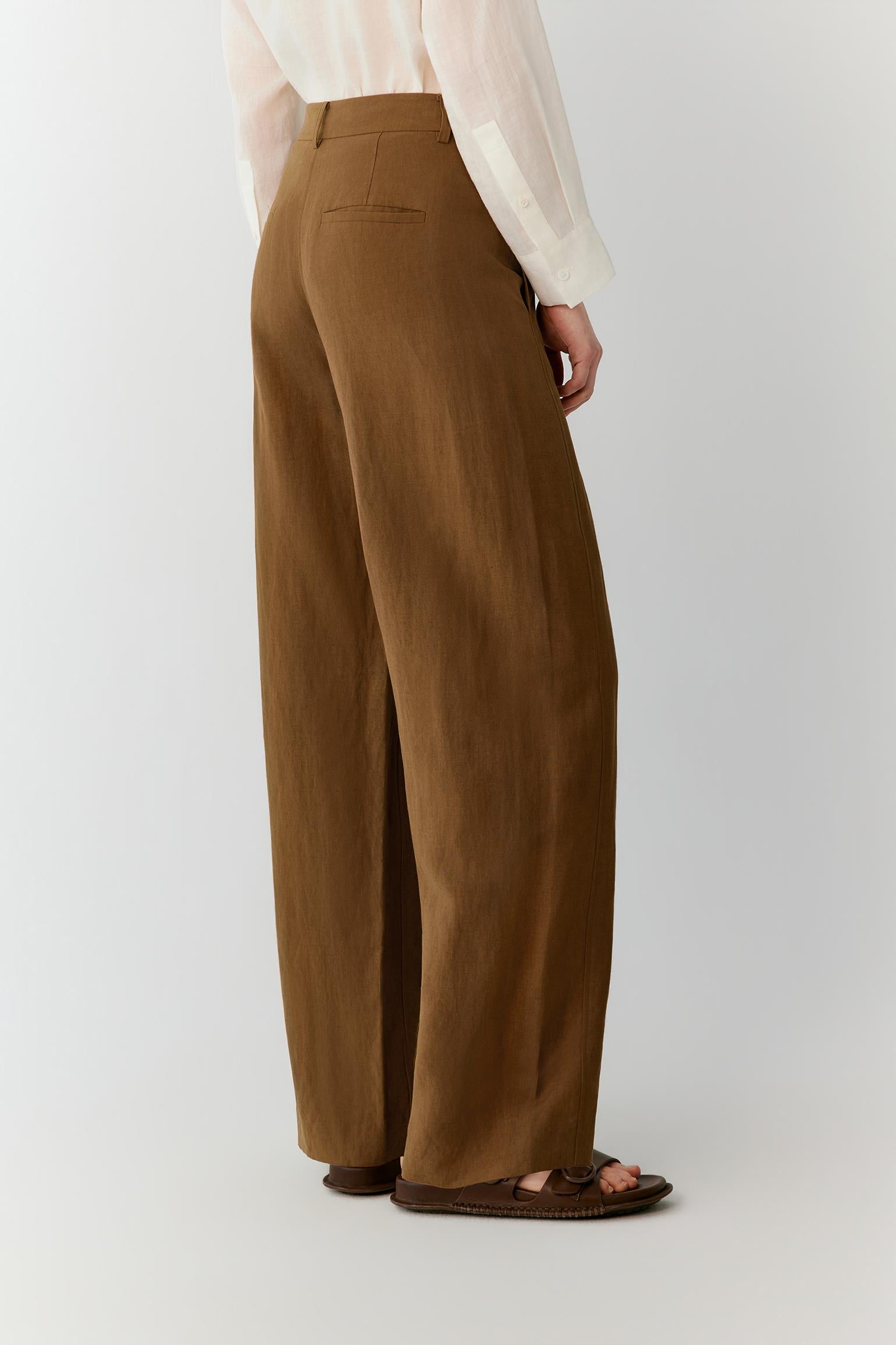 Side view highlighting the straight-leg construction and the fluid drape of the lightweight fabric. The image emphasizes the clean side seam, relaxed silhouette and natural movement of the trousers.