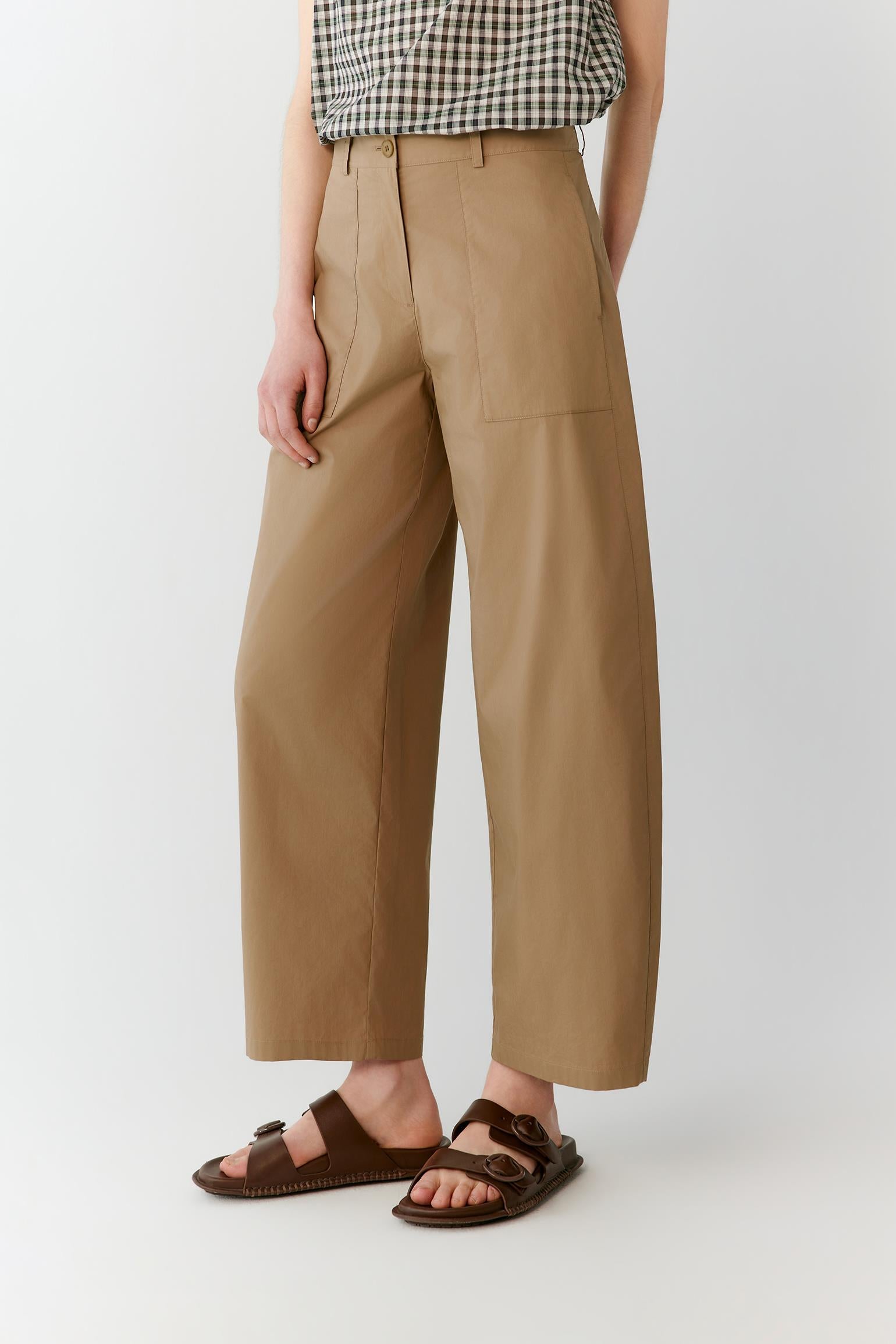 Full-length view focused on the trousers, emphasizing the straight-leg cut, relaxed proportions and natural movement of the lightweight cotton blend. The image highlights the fluid fall of the fabric from the waistband to the hem.